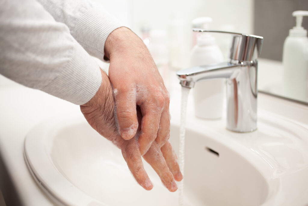 man washing hands with soap at h